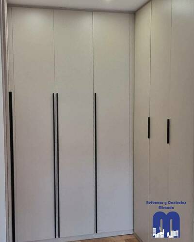 Armario empotrado a medida en un piso de Gijón, diseñado para aprovechar al máximo el espacio con un acabado elegante y funcional.