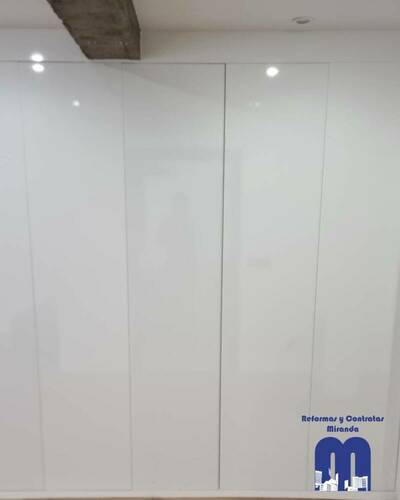Armario empotrado a medida en un piso de Gijón, diseñado para aprovechar al máximo el espacio con un acabado elegante y funcional.
