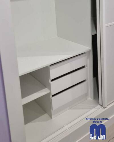Armario empotrado a medida en un piso de Gijón, diseñado para aprovechar al máximo el espacio con un acabado elegante y funcional.