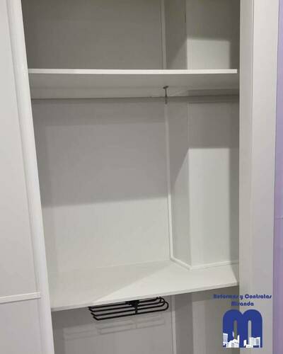 Armario empotrado a medida en un piso de Gijón, diseñado para aprovechar al máximo el espacio con un acabado elegante y funcional.
