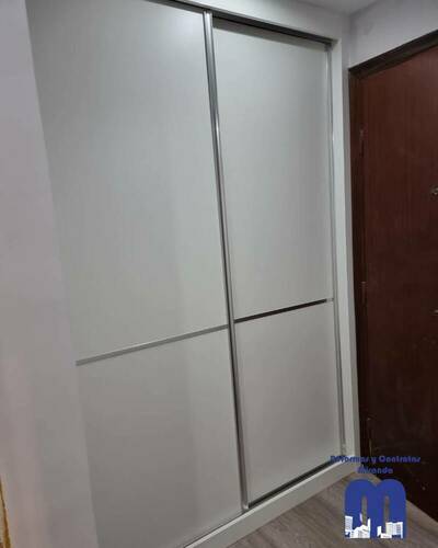 Armario empotrado a medida en un piso de Gijón, diseñado para aprovechar al máximo el espacio con un acabado elegante y funcional.