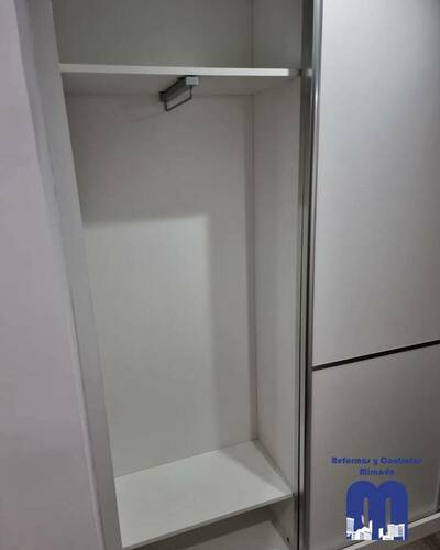 Armario empotrado a medida en un piso de Gijón, diseñado para aprovechar al máximo el espacio con un acabado elegante y funcional.