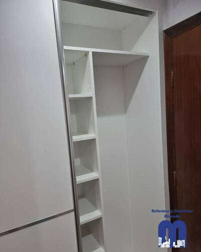 Armario empotrado a medida en un piso de Gijón, diseñado para aprovechar al máximo el espacio con un acabado elegante y funcional.