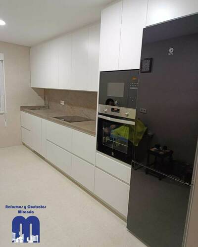 Reforma integral de cocina con mobiliario blanco y encimera Nebula Brown