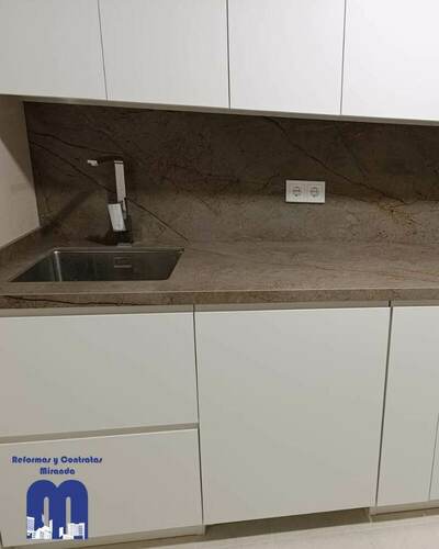 Reforma integral de cocina con mobiliario blanco y encimera Nebula Brown