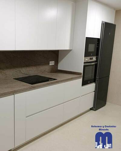 Reforma integral de cocina con mobiliario blanco y encimera Nebula Brown