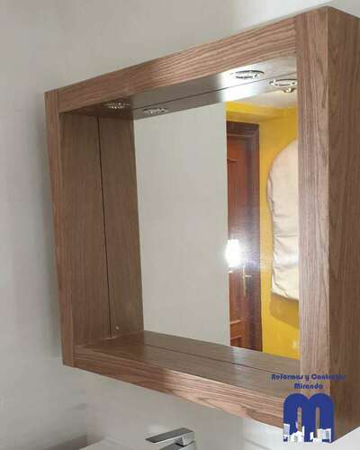 Reforma integral de baño moderno con acabados en madera y tonos piedra