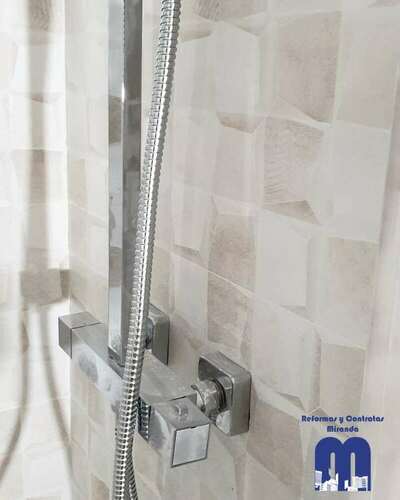 Reforma integral de baño moderno con acabados en madera y tonos piedra