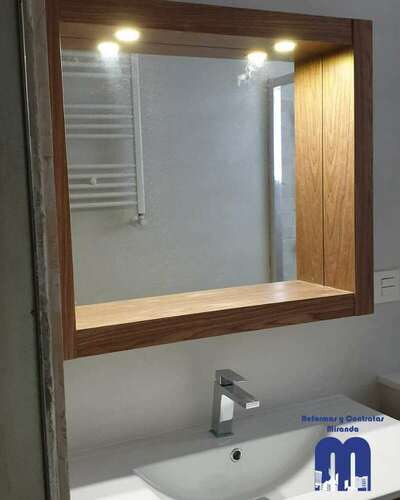 Reforma integral de baño moderno con acabados en madera y tonos piedra