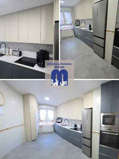 Reforma integral de cocina moderna con mobiliario en acabado tacto seda Fenix verde comodoro y beige, encimera y frente porcelánico Coverlam imitación mármol, suelo vinilico gris, fregadero bajo encimera y grifo monomando flexible de color negro.